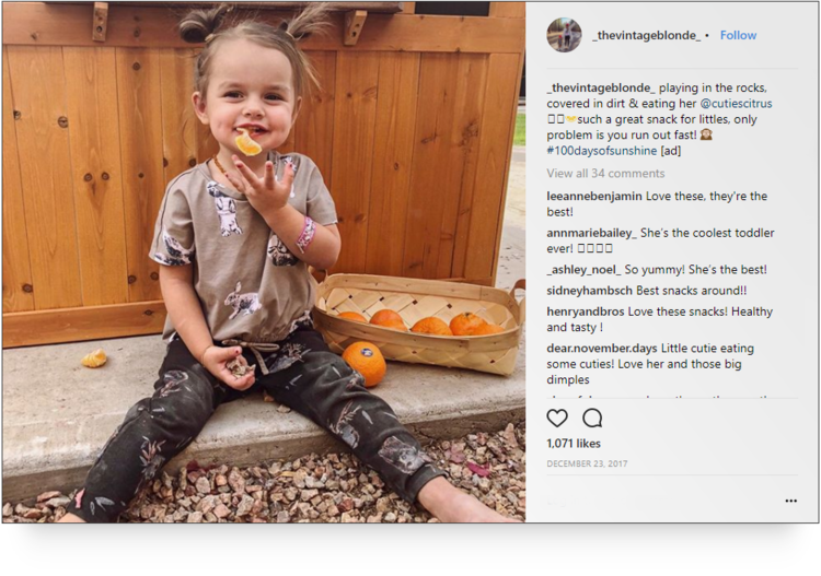 screenshot of Instagram post by fashion influencer @_thevintageblonde_ of her daughter eating fruit