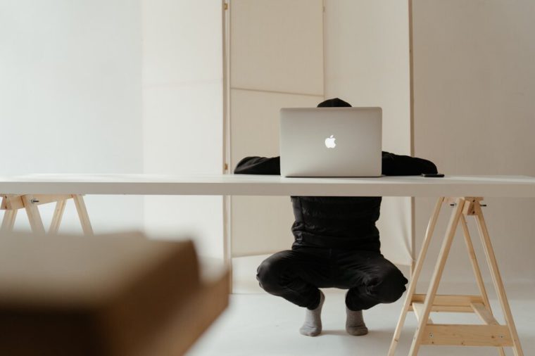 pic of someone kneeling in front of a laptop
