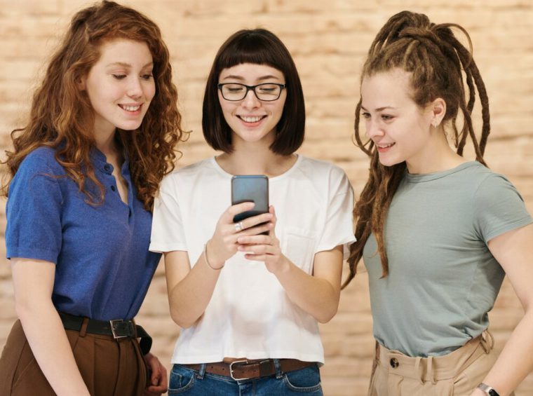 pic of three women looking at a cellphone