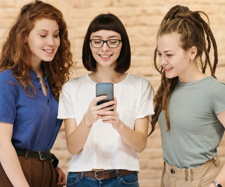 pic of three women looking at a cellphone