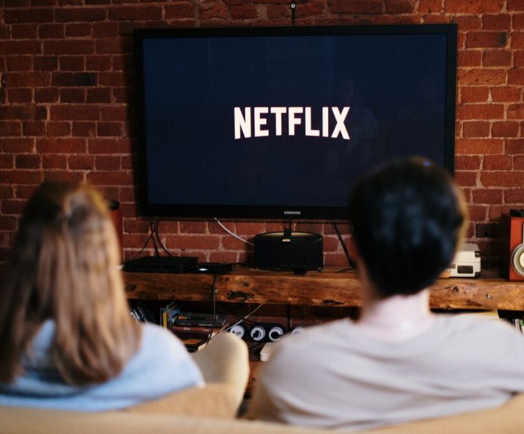 Pic of two people watching Netflix - less TV spend
