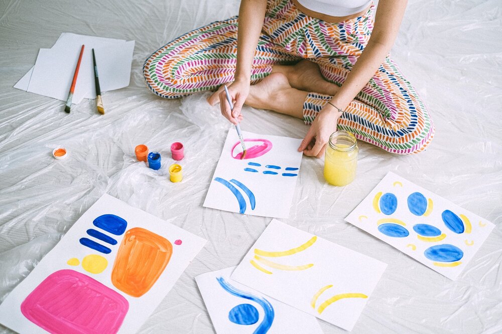 pic of a painter with canvasses sitting on the floor