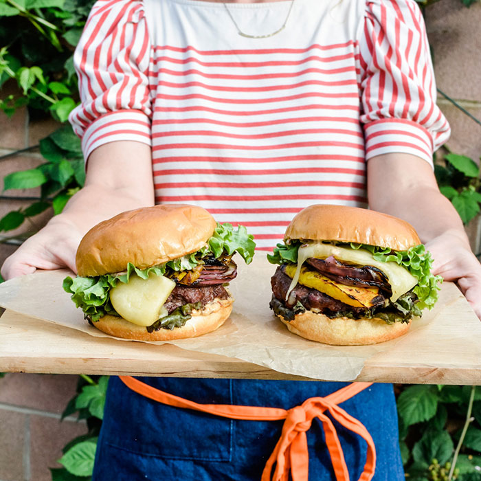 Pic of gourmet burgers on a wooden platter - Kate Ramos for St. Pierre Bakery