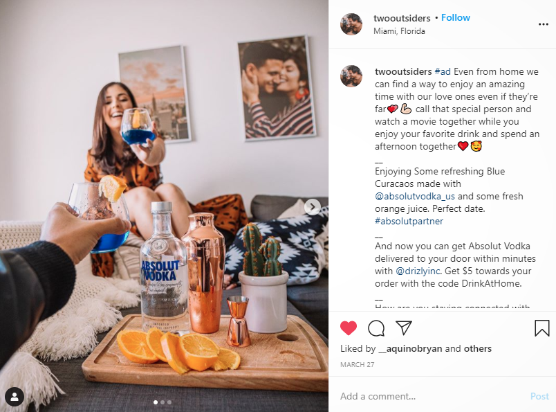 Instagram couple @twooutsiders toasting in an Absolut x Drizly sponsored post on Insta driving traffic to Drizly's Instagram page for $5 coupon