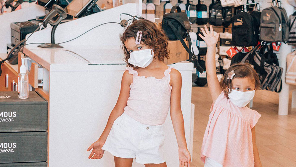 Two small girls wearing face masks inside a store for Famous Footwear influencer campaign