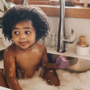 Baby taking a bath in kitchen sink for The Honest Company influencer campaign