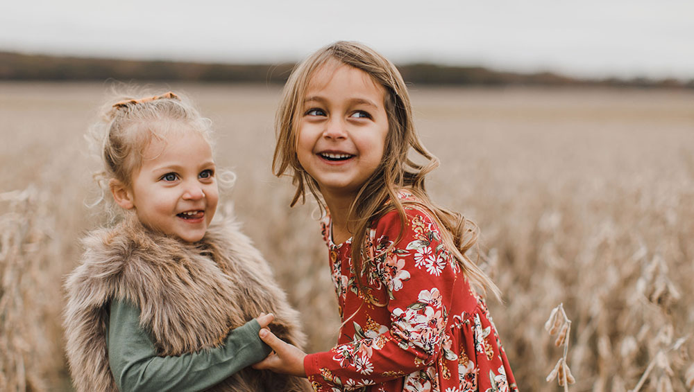 2 girls holsind hands and smiling for The Smile Generation influencer campaign