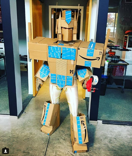 Post from @CARONARNOLD displaying a transformer's costume made of cardboard boxes on Instagram.