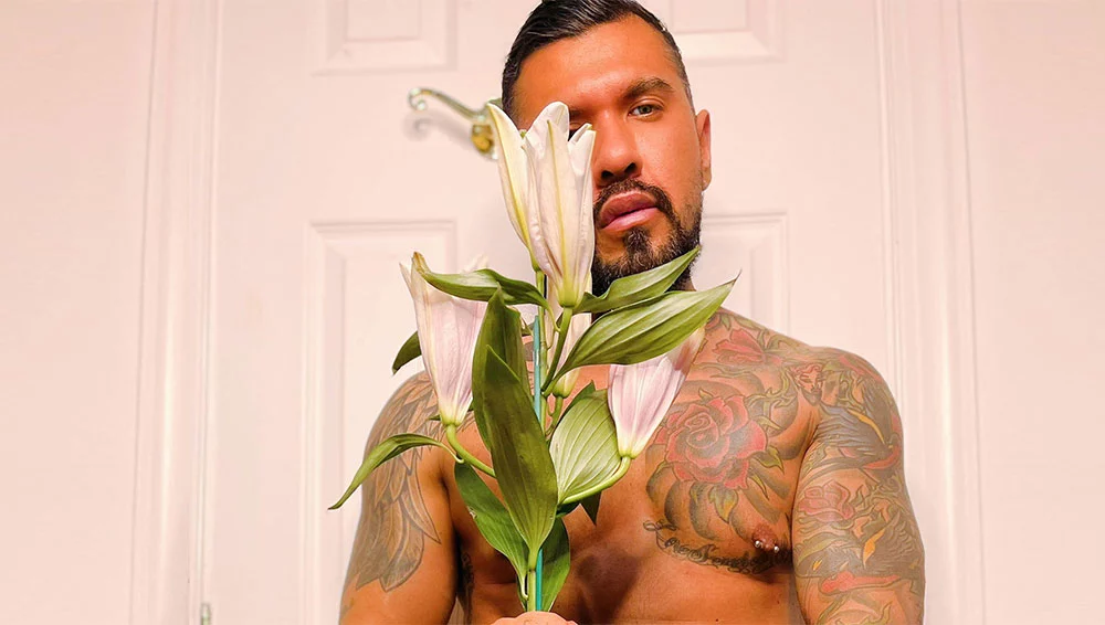 Tatooed man holding up a flower